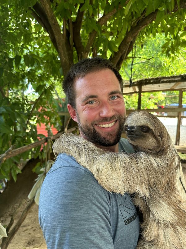 Davis holding a sloth at a sanctuary